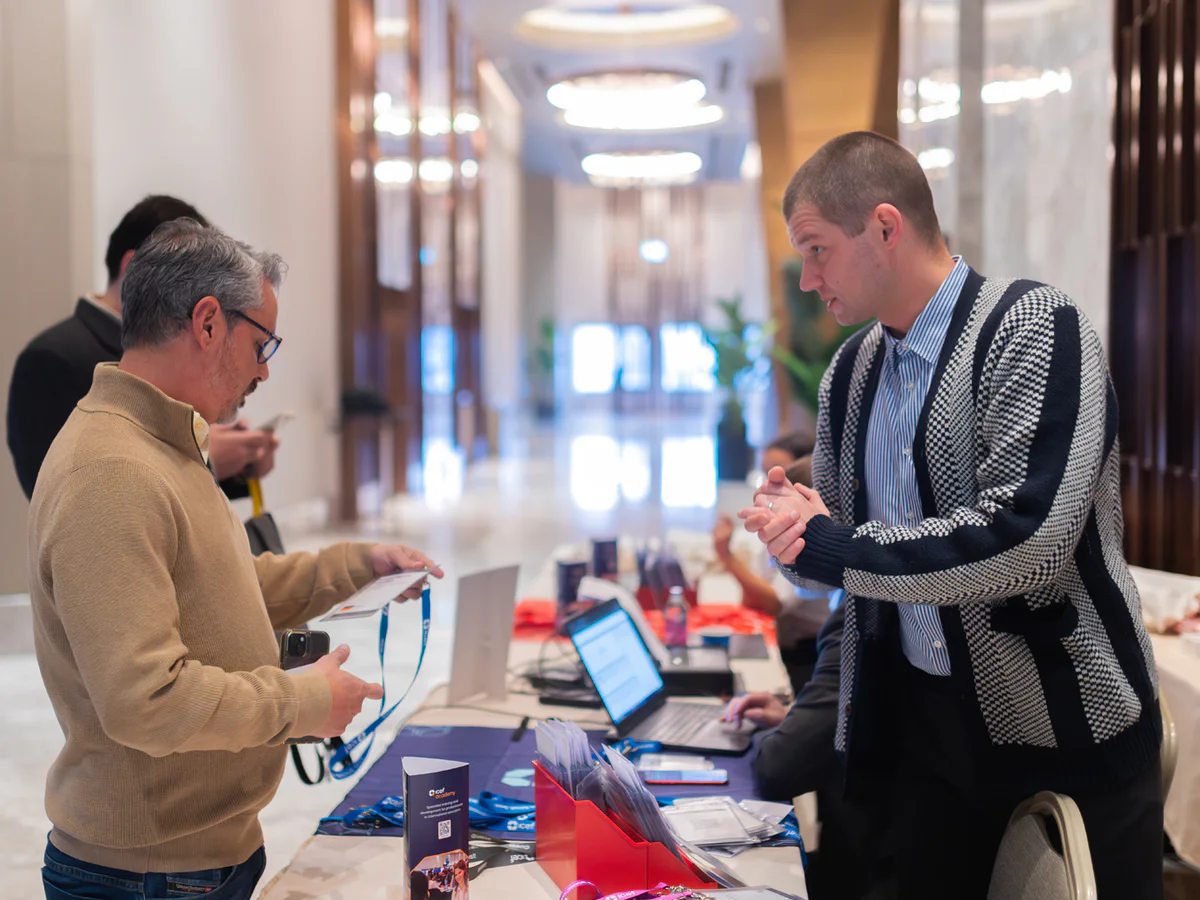 Attendees speaking at a corporate conference registration desk